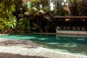 a swimming pool with a bench in a yard at Pausa Trancoso in Trancoso