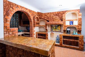 a large kitchen with a brick wall and a table at VIca Guest House con piscina en la entrada de la Zona Hotelera in Cancún