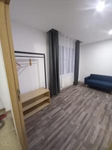 an empty room with a blue couch and a bed at Suite Noire et Blanche in Saint-Paul-de-Fenouillet