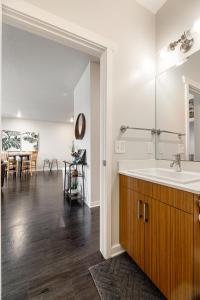 a bathroom with a sink and a kitchen with a table at Trailside Charm TART Trail Downtown in Traverse City