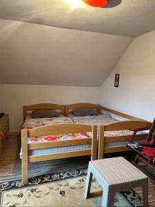 a bedroom with two bunk beds in a attic at Vikendica Krivaja sa bazenom i privatnom plažom in Zavidovići