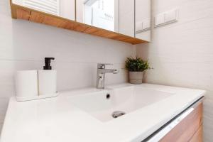 a bathroom with a white sink and a mirror at Luxury Apartment on Zlota Street in Warsaw +8 photos