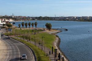 a road next to a body of water with a street at Grande apartamento a 14 km de Lisboa in Laranjeira