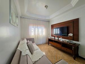 un soggiorno con divano e TV a schermo piatto di Casa Quintal Amplo prox Cataratas 4 quartos a Foz do Iguaçu