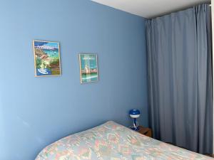 1 dormitorio azul con 1 cama y 2 posters en la pared en T3 St Malo- plage La Hoguette avec Jardin, en Saint-Malo