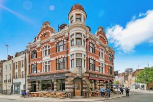 a large brick building with people standing in front of it at DESIGNER Victorian Flat with HUGE Terrace in London