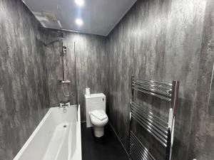 a bathroom with a toilet and a bath tub at Albion Apartment by Klass Living Coatbridge in Coatbridge