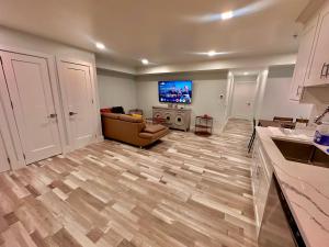 a living room with a couch and a flat screen tv at The Trendy Suite - Upgraded 2BR with Luxe Amenities in Paterson