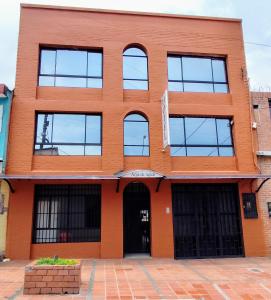 an orange brick building with windows at Hotel Arpa de Aguas in Villavicencio