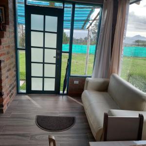 Una sala de estar con un sofá y una ventana grande. en Private Casita near UIO airport, en Hacienda Otón