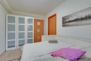a bedroom with a bed and a painting on the wall at Apartament 48 in Gdańsk