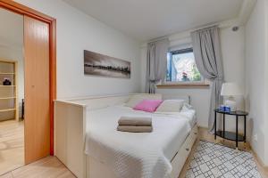 a bedroom with a white bed with two towels on it at Apartament 48 in Gdańsk
