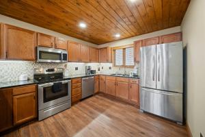 a kitchen with wooden cabinets and stainless steel appliances at On Beech Time in Beech Mountain