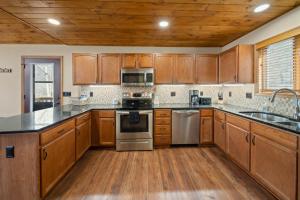 a kitchen with wooden cabinets and stainless steel appliances at On Beech Time in Beech Mountain