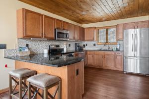 a kitchen with wooden cabinets and a stainless steel refrigerator at On Beech Time in Beech Mountain +31 photos