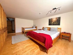 a bedroom with a large bed with a red blanket at Ferienwohnung Poldi - Annehmlichkeiten von 4-Sterne Familien- und Wellnesshotel Viktoria können mitgenutzt werden in Oberstdorf +13 photos