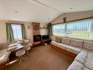 a living room with a couch and a table at Poppys Place in Ingoldmells
