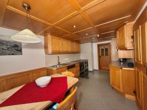 a kitchen with wooden cabinets and a table with a bowl on it at Ferienwohnung Poldi - Annehmlichkeiten von 4-Sterne Familien- und Wellnesshotel Viktoria können mitgenutzt werden in Oberstdorf