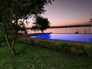 a swimming pool next to a body of water at Muca House in Thohoyandou