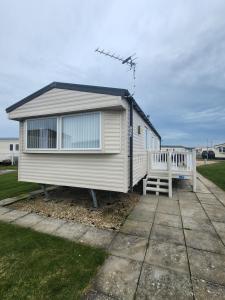 a tiny house with a porch and a bench at Poppys Place in Ingoldmells