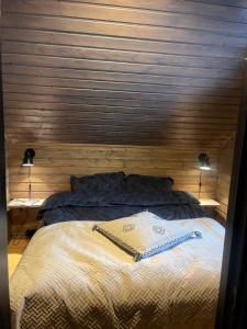 Un dormitorio con una cama con una pared de madera. en Hytte i vakre Reisadalen, en Storslett