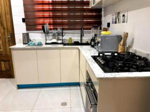 a kitchen with a stove and a counter top at Norichyank Apartments in Amasaman +7 photos