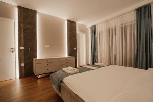 a bedroom with a bed and a dresser and a mirror at Darki Comfort Apartments - Stylish and Comfortable Apartments with Free Parking in Ohrid