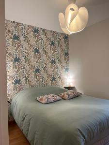 Una cama con dos almohadas encima en un dormitorio. en Le lodge, en Le Crotoy