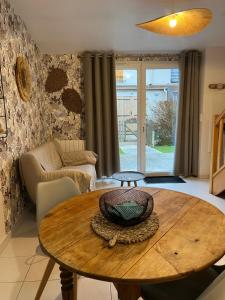 a living room with a wooden table and a couch at Le lodge in Le Crotoy