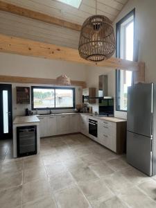 a large kitchen with a refrigerator and a window at Maison entre océan et forêt landaise in Vielle-Saint-Girons