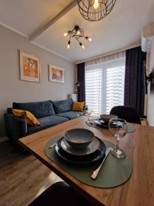 una sala de estar con una mesa y un sofá en Apartament Busko Odnova, en Busko-Zdrój