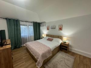 a bedroom with a bed and a window with green curtains at Bavaria Rooms in Iaşi