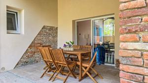 a wooden table and chairs on a patio at La maisoun d'odette in Mérenvielle