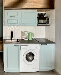 a kitchen with a washing machine and a microwave at Seafront Apartment with air conditioner in Empuriabrava