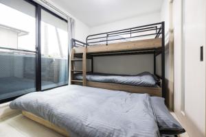 two bunk beds in a room with a window at Villetta Imari Ekimae III Villetta Imari Ekimae II - Vacation STAY 19025 in Imari