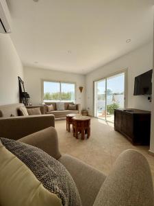 a living room with a couch and a table at Villa Paco Djerba 2 suites et piscine privée in Taguermess