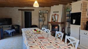a dining room with a long table and a fireplace at Les 2 étangs de la Foulonnerie in Saint-Jean-Saint-Germain