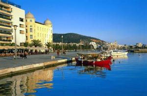 a red boat sitting in the water next to a building at Mona Lisa Guest House in Volos
