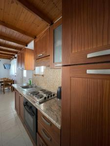 a kitchen with wooden cabinets and a stove top oven at Levante Apartment for 4 in Faliraki