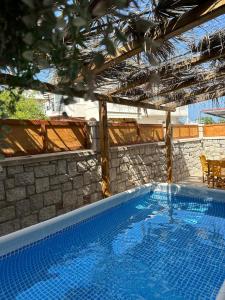 a large swimming pool in a house with a stone wall at Levante Apartment for 4 in Faliraki