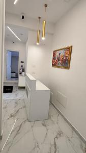 une chambre blanche avec un tableau sur le mur dans l'établissement Giurò, à Naples
