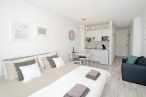 Un dormitorio blanco con una cama grande y una cocina. en Modern Ponderosa, Las Americas, en Csta Adje