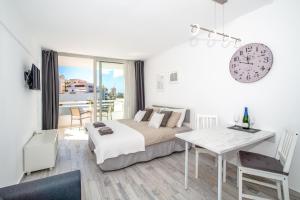 1 dormitorio con cama, escritorio y reloj en Modern Ponderosa, Las Americas, en Csta Adje