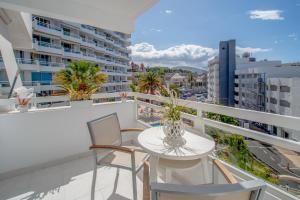 Un balcón con mesa y sillas y vista a una ciudad. en Modern Ponderosa, Las Americas, en Csta Adje