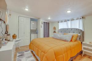 ein Schlafzimmer mit einem Bett mit einer orangefarbenen Decke in der Unterkunft Walk to Memorial Stadium Family Home with Patio in Lincoln