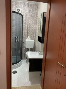 a bathroom with a shower and a sink and a toilet at Ralin Apart in Prizren