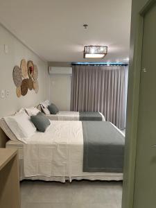 a bedroom with two beds and a window at Gran Lençóis Flat Residence Mandacaru 311 - 611 in Barreirinhas