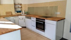 a kitchen with white appliances and a wooden counter top at Ferienhäuschen mit Hof in Birlenbach in Birlenbach