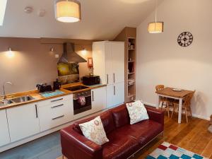Una sala de estar con un sofá y una cocina. en Sennen Cove, The Hedgerows, near 14 beaches,, en Penzance