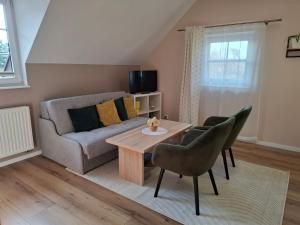 ein Wohnzimmer mit einer Couch und einem Tisch und Stühlen in der Unterkunft Pokoje u Magdy in Kazimierz Dolny